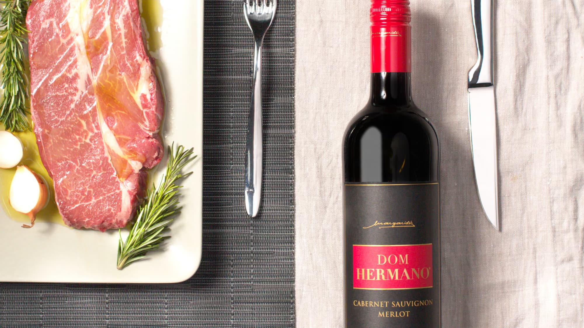 Dom Hermano Cabernet Sauvignon Merlot mit Steak, Rosmarin und Tischdekoration