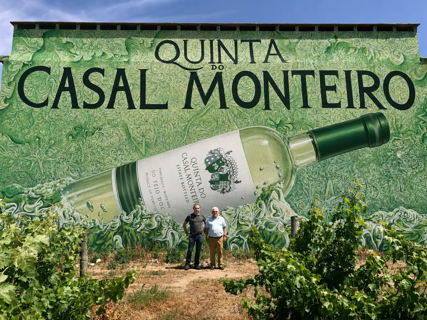 Menschen im Weinberg vor dem Wandgemälde der Quinta